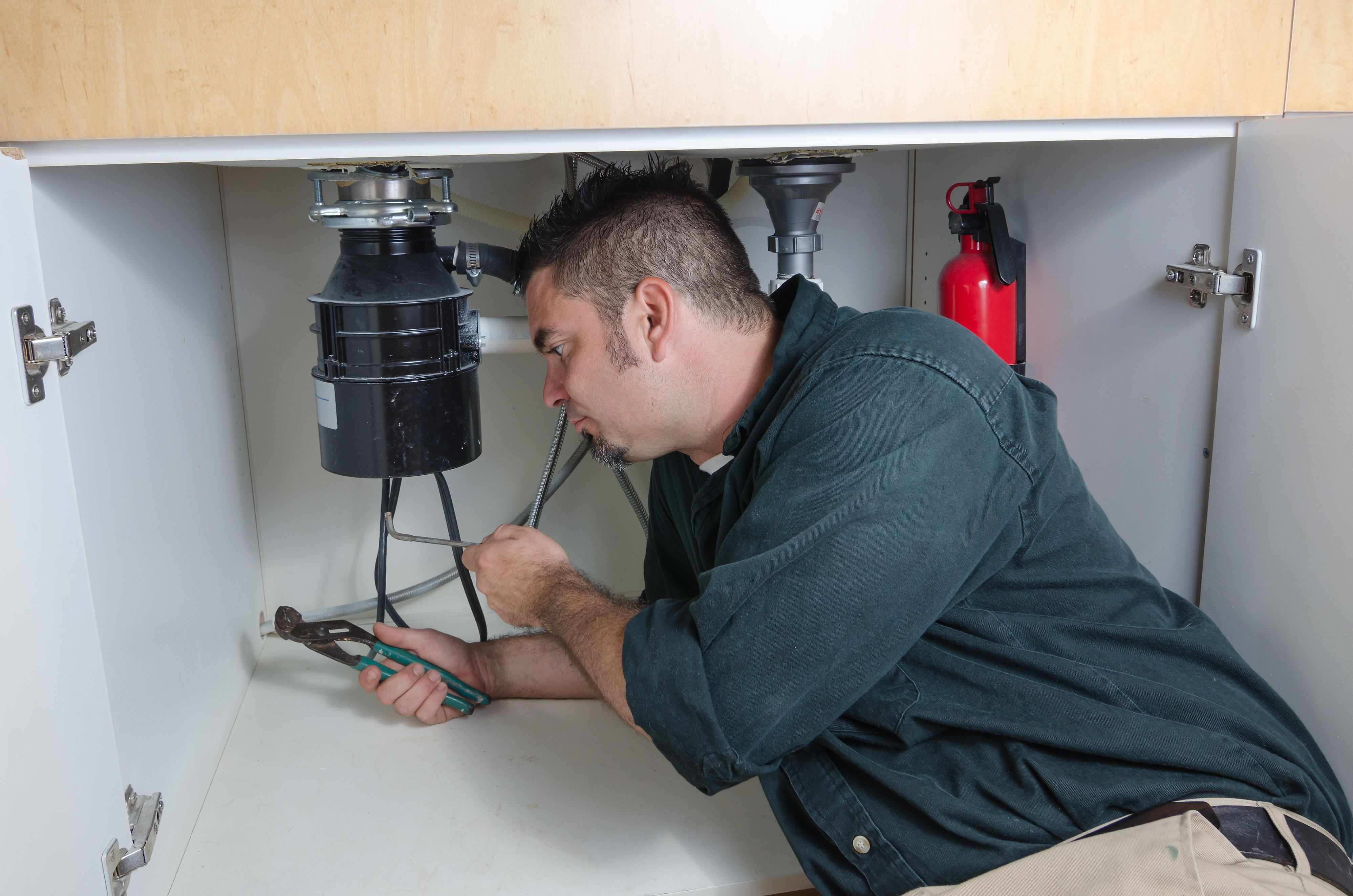 technician installing garbage disposal